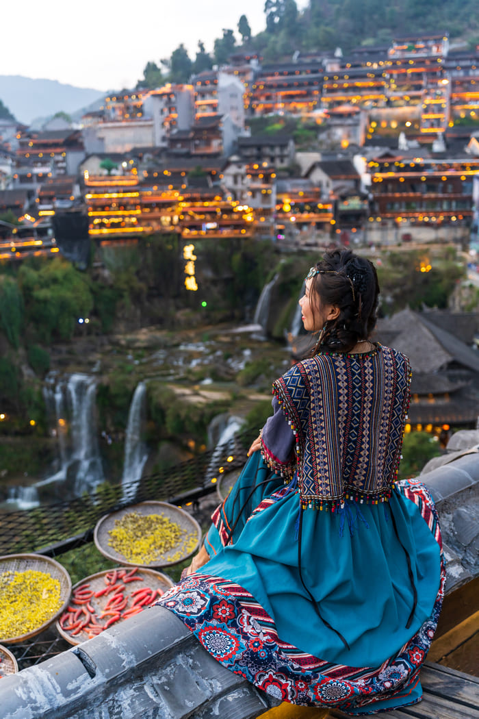mujer china admirando el paisaje de la ciudad lijang